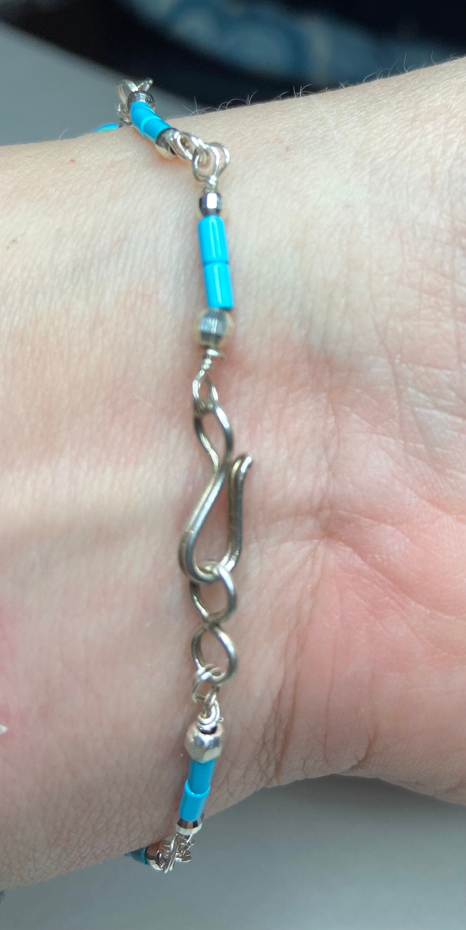 Sterling silver bracelet with turquoise beads and a hook clasp.