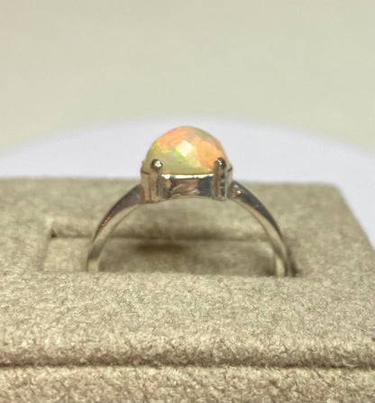 Sterling silver band ring with a faceted oval Ethiopian Wello opal.
