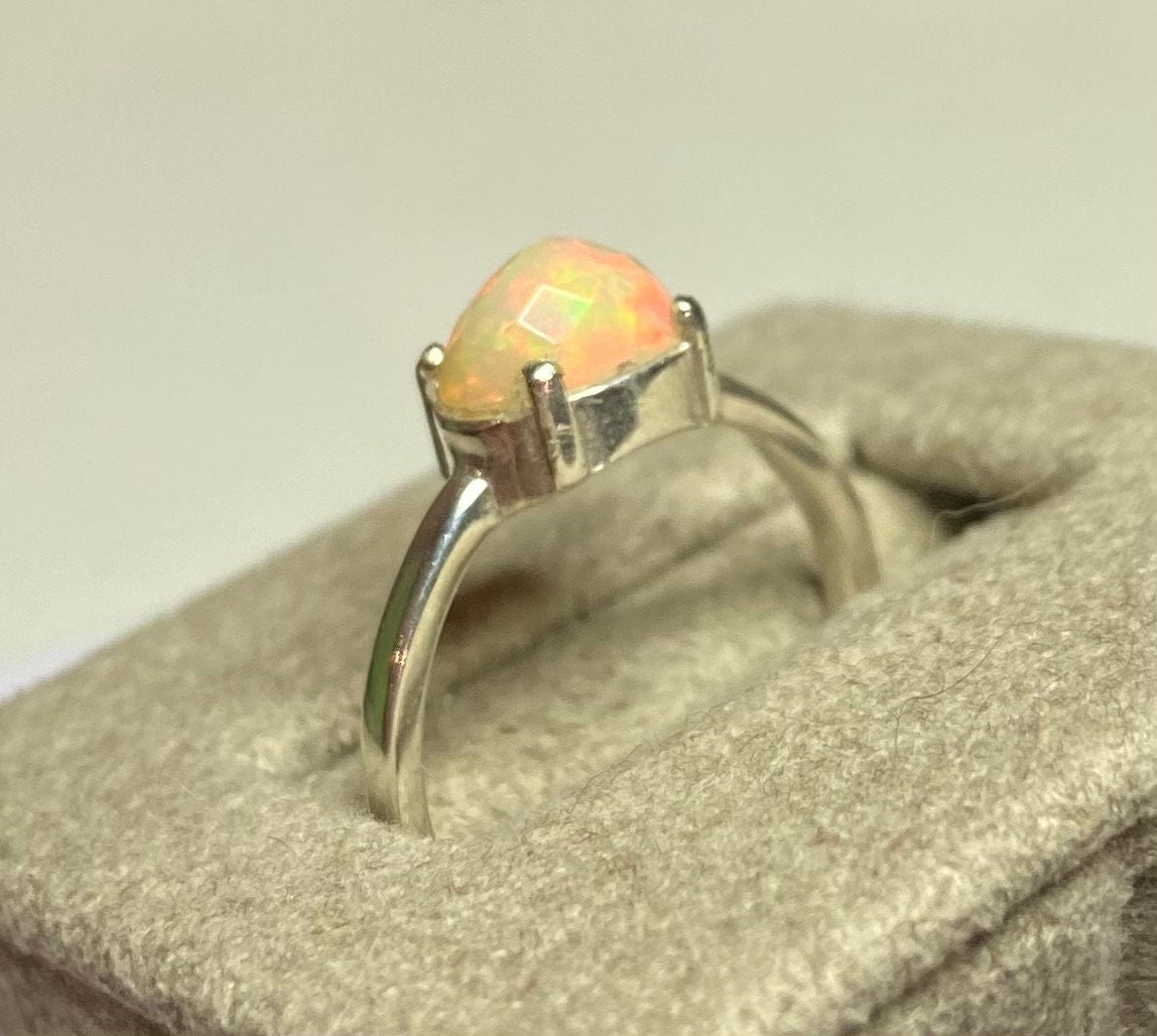 Sterling silver band ring with a faceted oval Ethiopian Wello opal.
