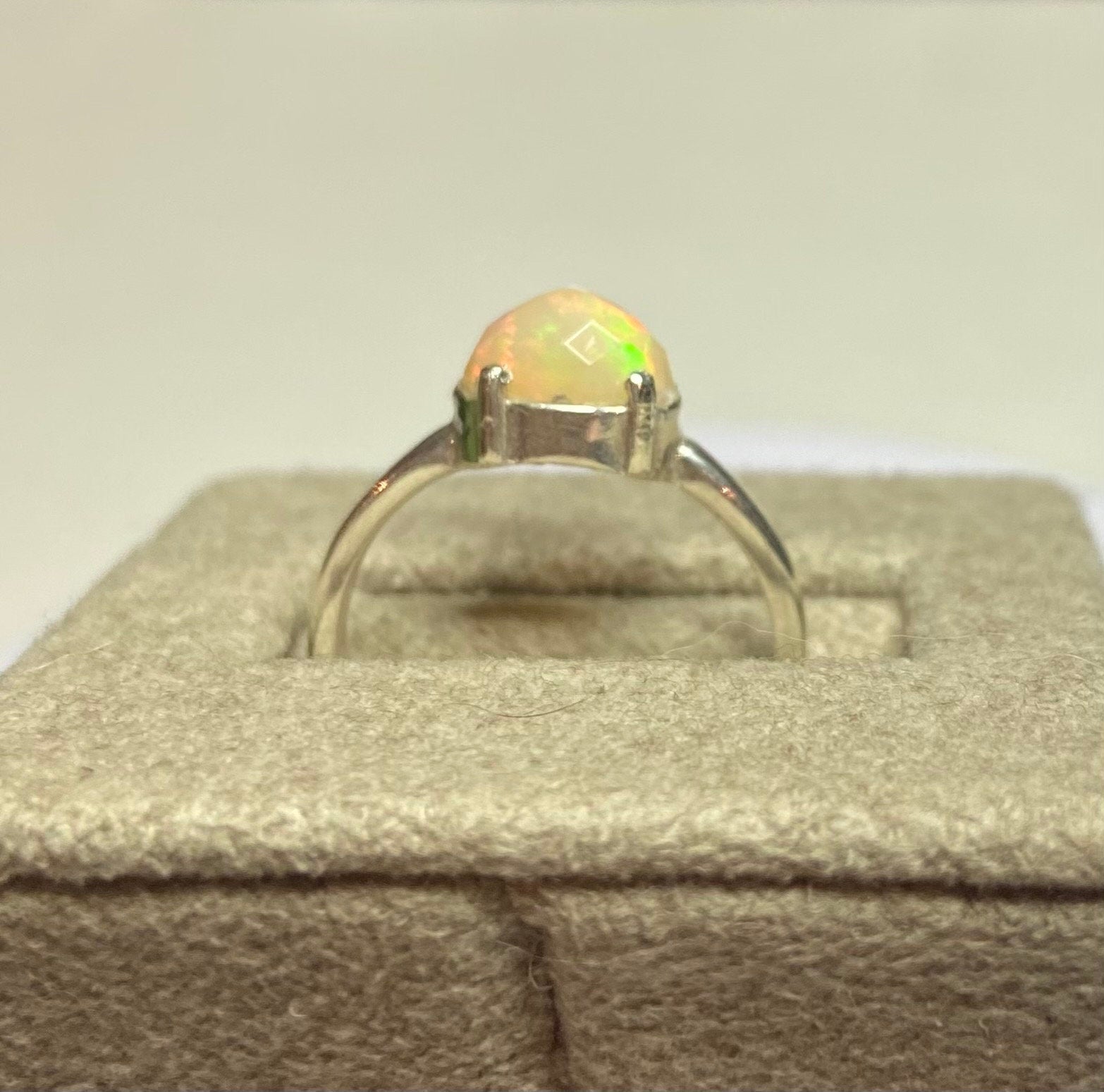 Sterling silver ring with a faceted oval Ethiopian Wello opal.