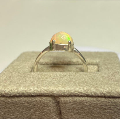 Sterling silver ring with a faceted oval Ethiopian Wello opal.