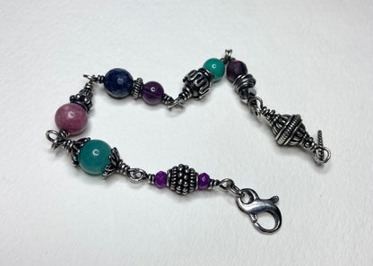 Sterling silver beaded bracelet with multi-colored gemstones and a lobster clasp.