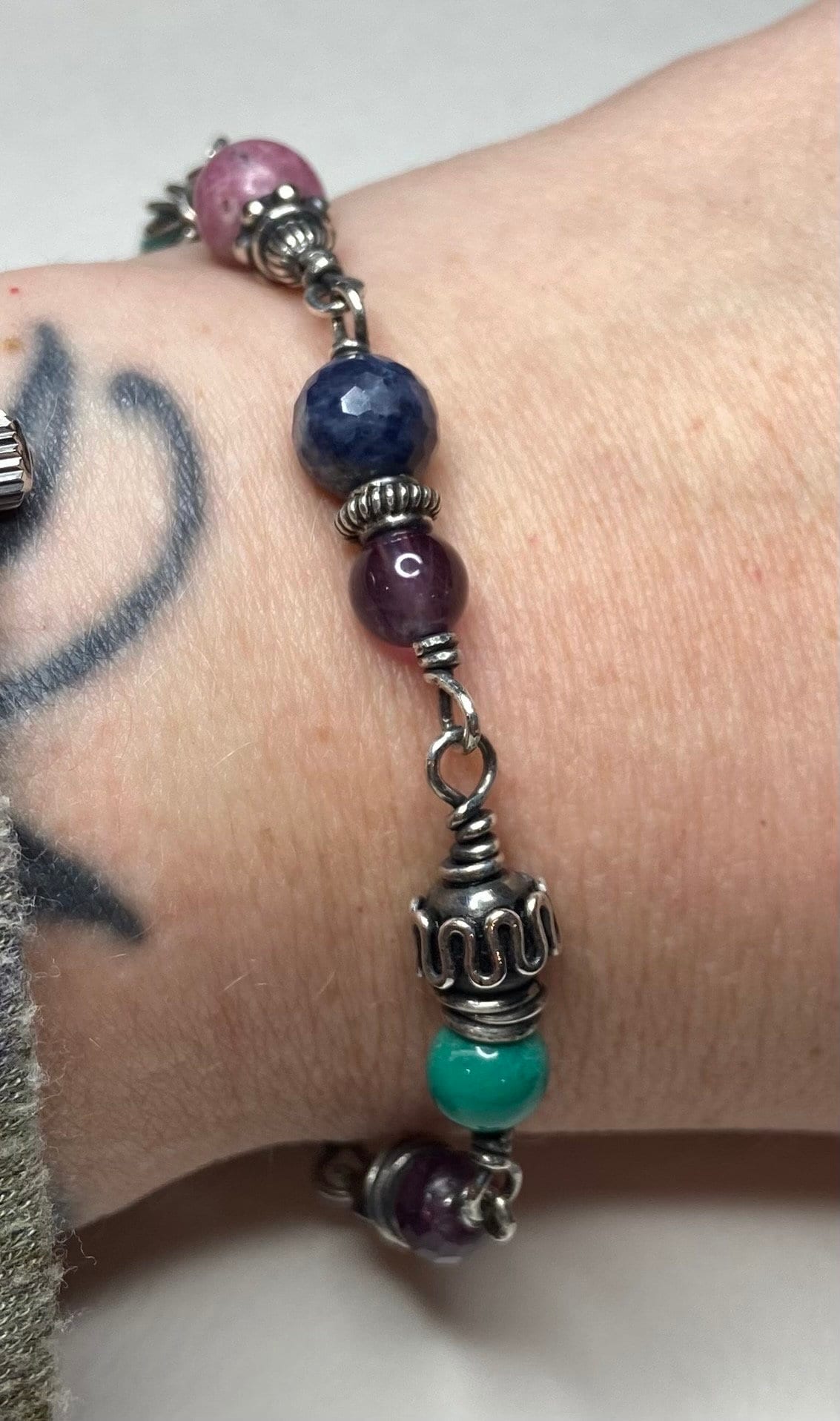 Sterling silver beaded bracelet with multi-colored gemstones.