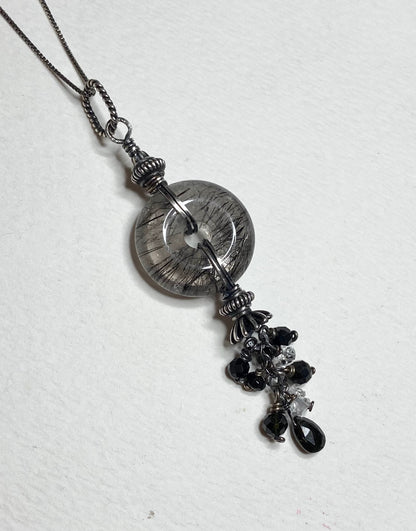 Sterling silver necklace with a tourmalated quartz donut pendant and a tassel of tourmaline and herkimer diamond quartz.