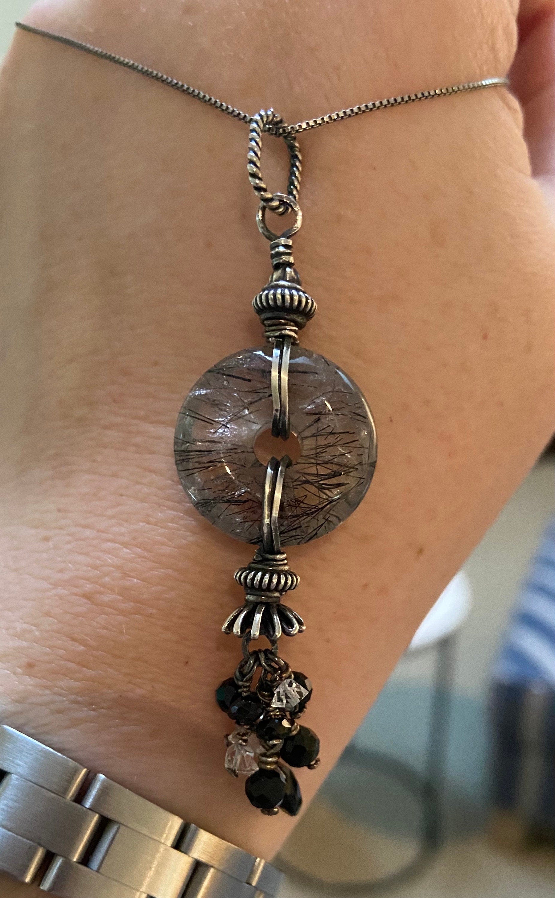 Sterling silver necklace with a tourmalated quartz donut pendant and a tassel of tourmaline and herkimer diamond quartz.