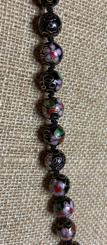 Cloisonné beaded necklace with black, pink, and gold floral designs.