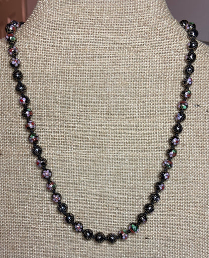 Cloisonné beaded necklace with black, pink, and gold floral designs.