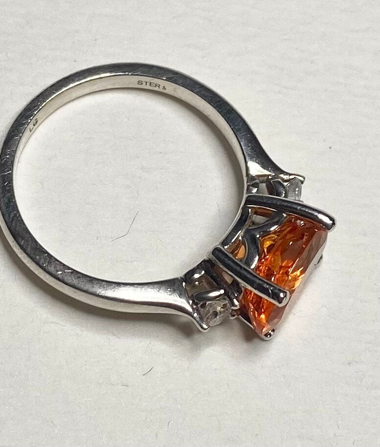 Sterling silver ring with a spessartite garnet and lab-grown diamonds.