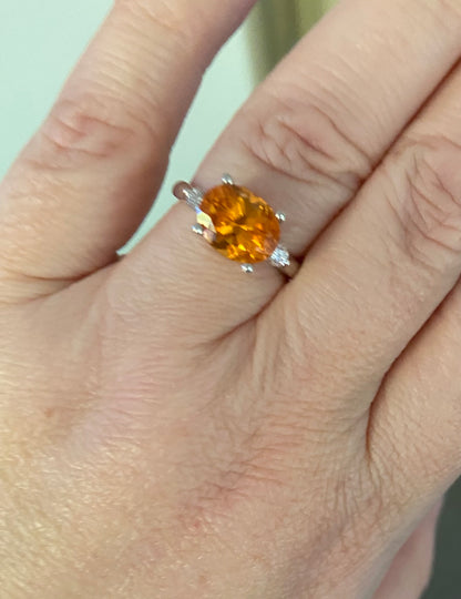 Sterling silver ring with oval spessartite garnet and two lab-grown diamonds.