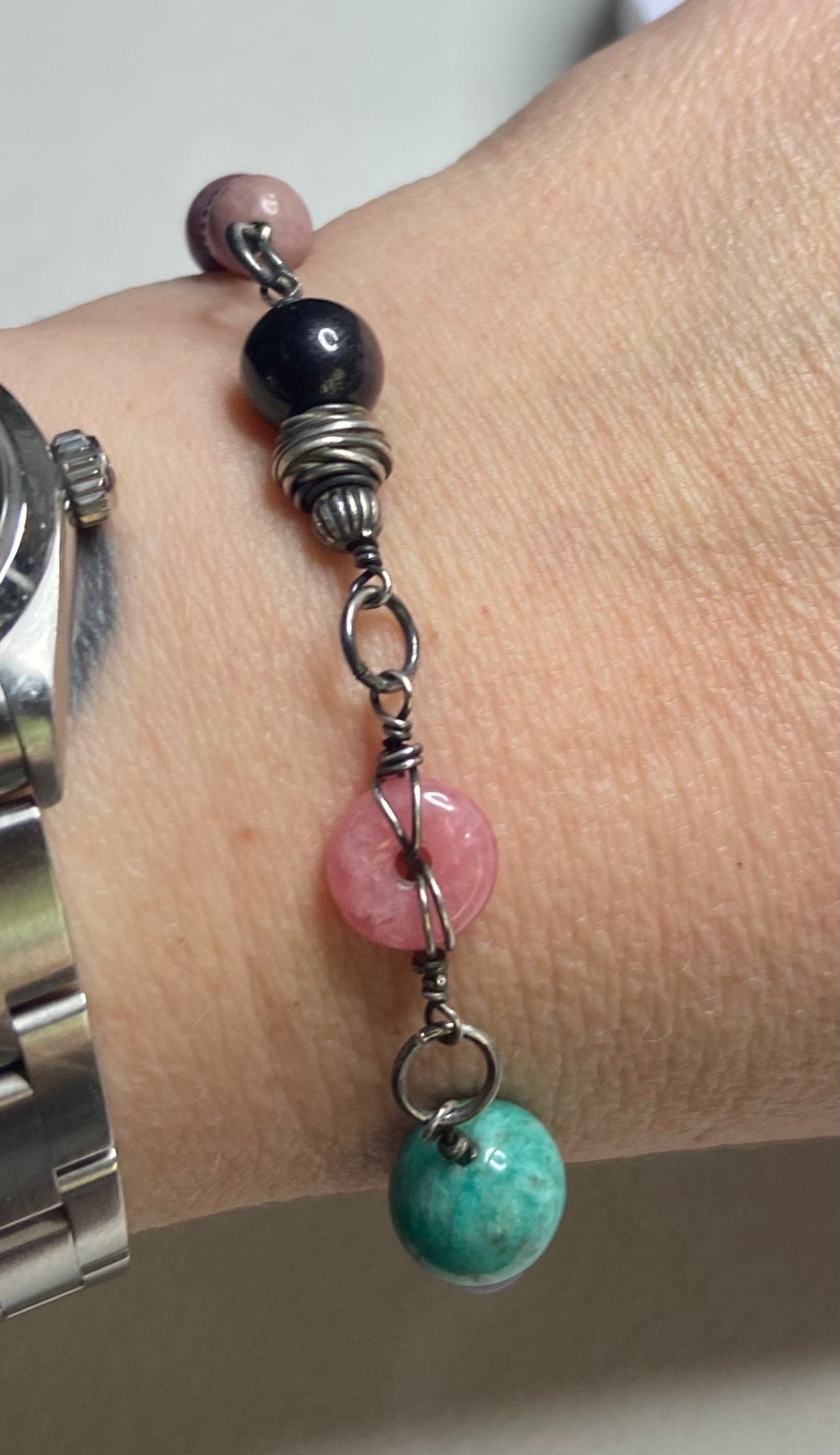 Sterling silver bracelet with multi-colored beads including pink, black, and turquoise.