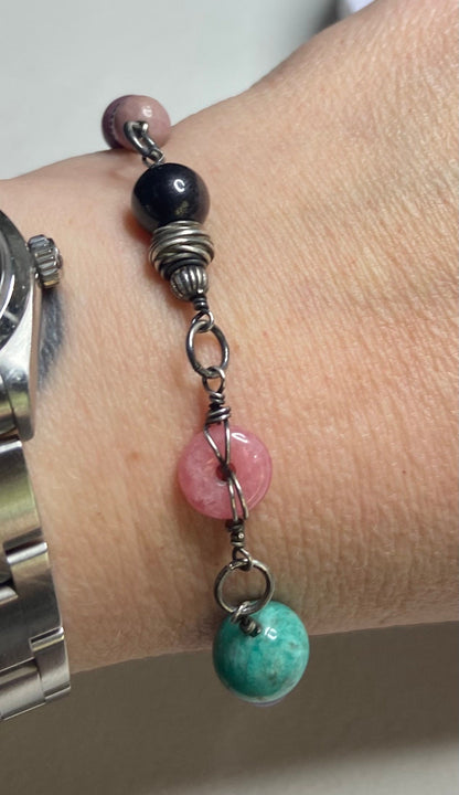 Sterling silver bracelet with multi-colored beads including pink, black, and turquoise.