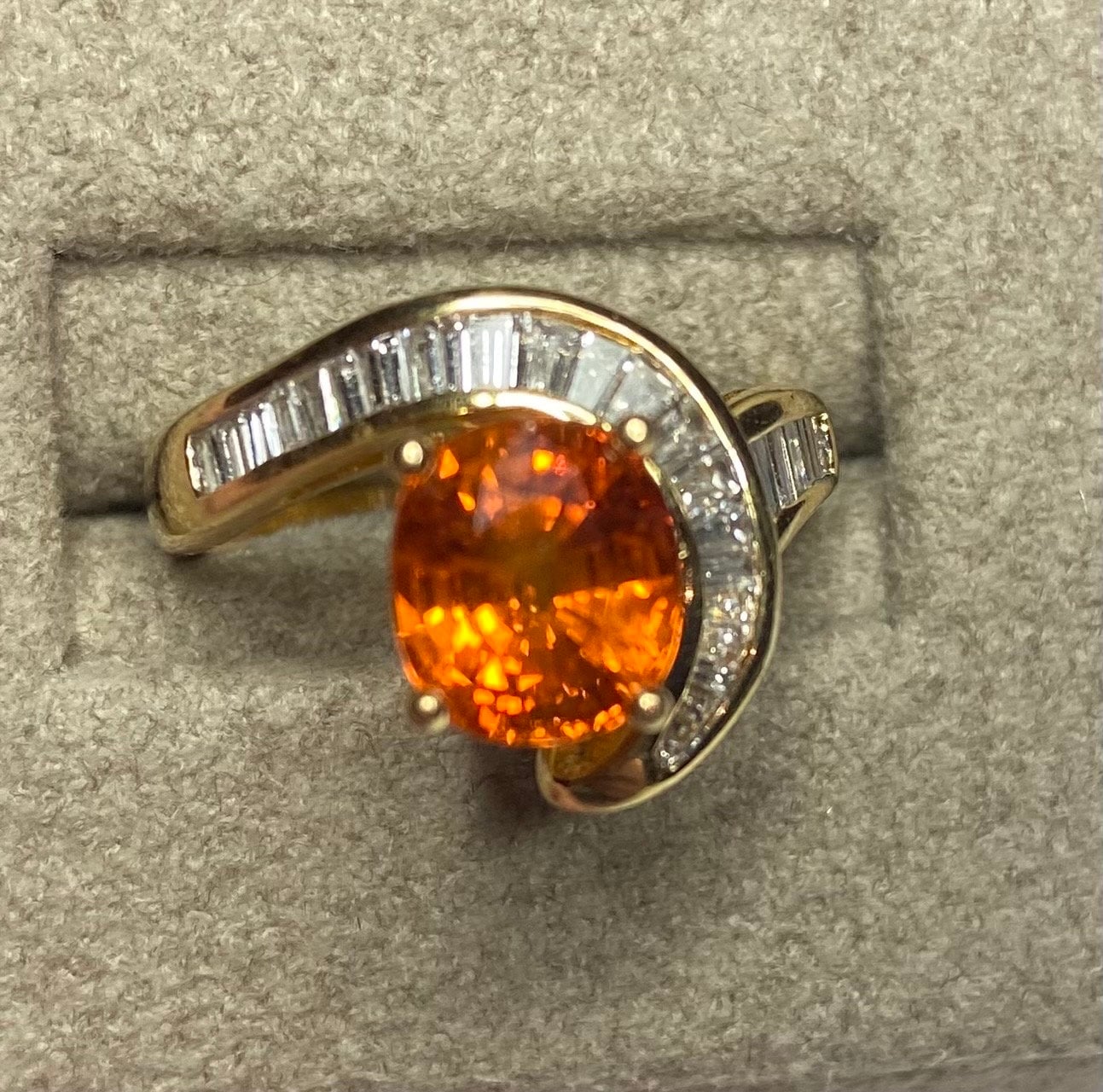 18k yellow gold ring with oval spessartite garnet and baguette diamonds.