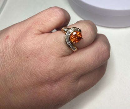 18k yellow gold ring with a spessartite garnet and baguette diamonds.