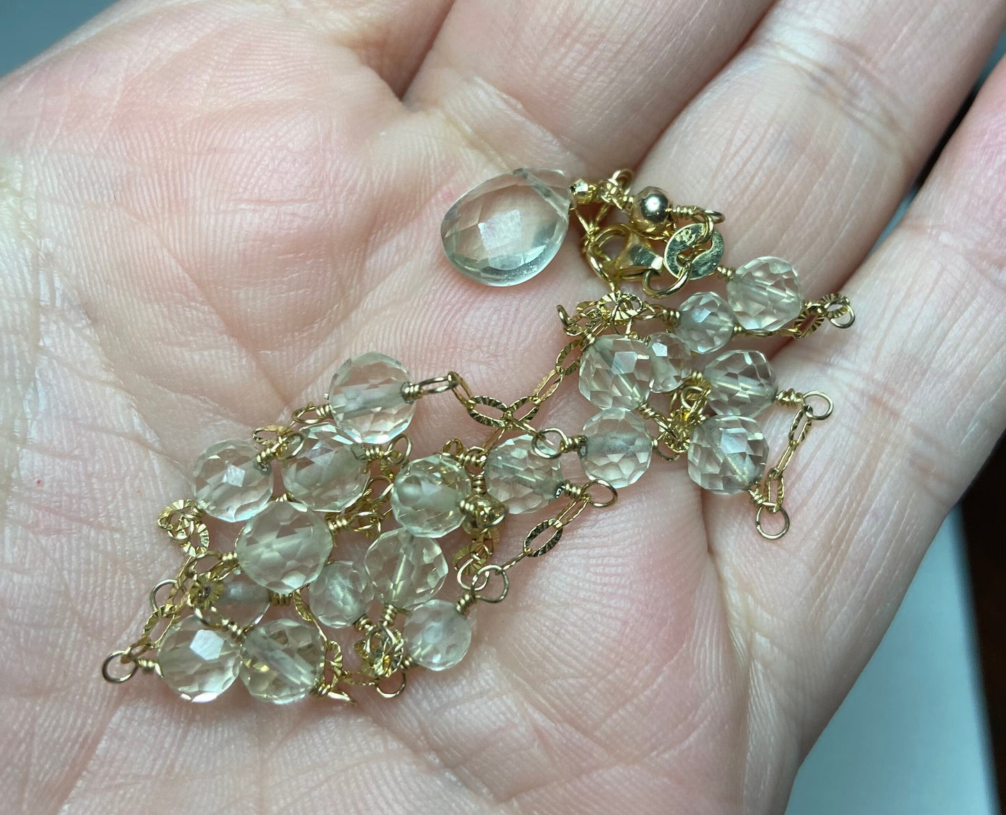 A 14k yellow gold choker necklace with light yellow Oregon Sunstone beads and a briolette pendant.