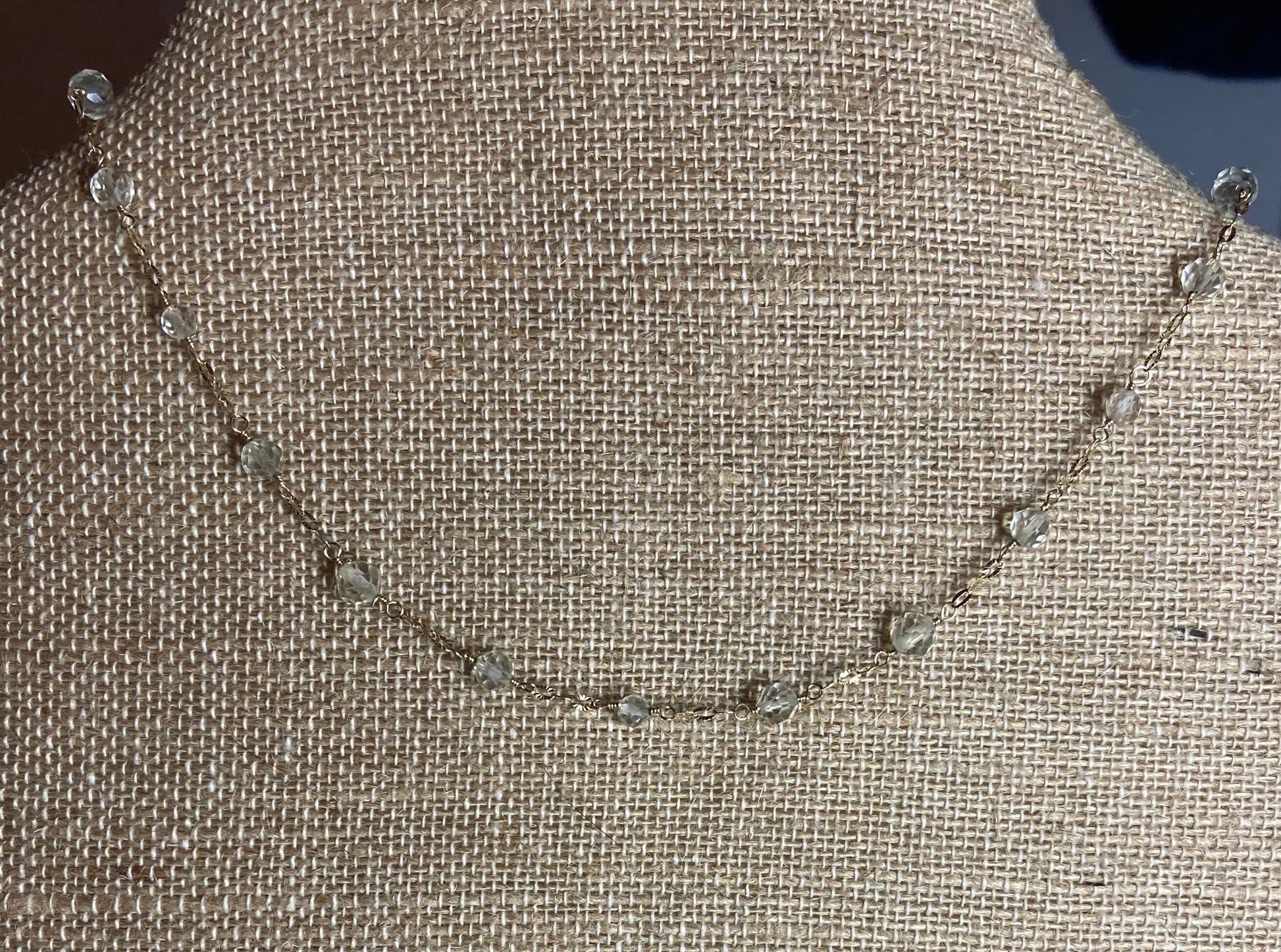 A delicate 14k yellow gold choker necklace with small, faceted light yellow beads.