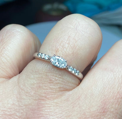 A 14k white gold band ring with a marquise-cut pink diamond and accent diamonds.