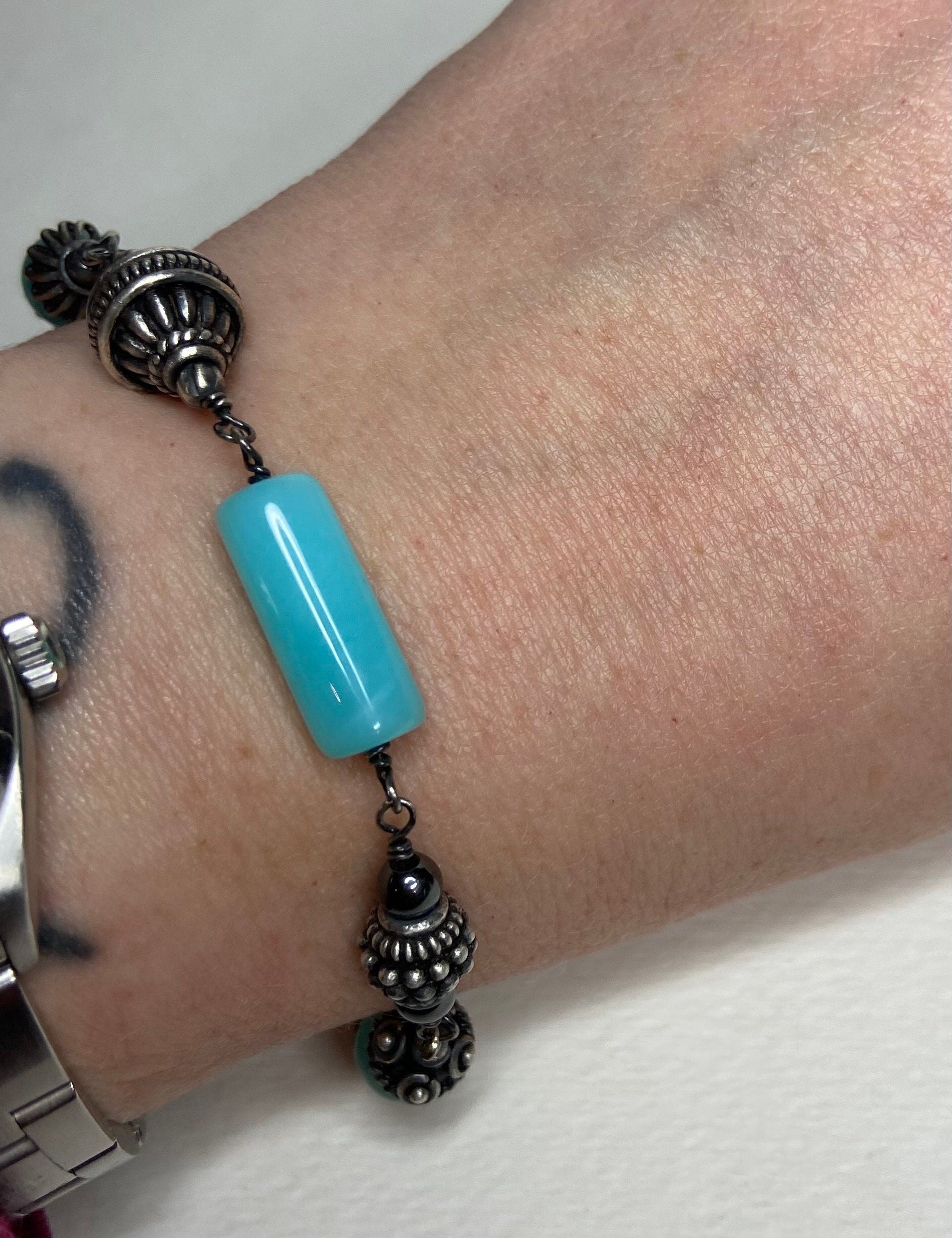 Sterling silver bracelet with a blue Peruvian opal bead and ornate silver beads.