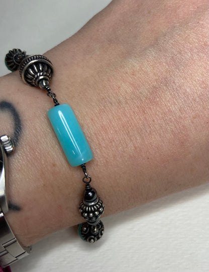 Sterling silver bracelet with a blue Peruvian opal bead and ornate silver beads.