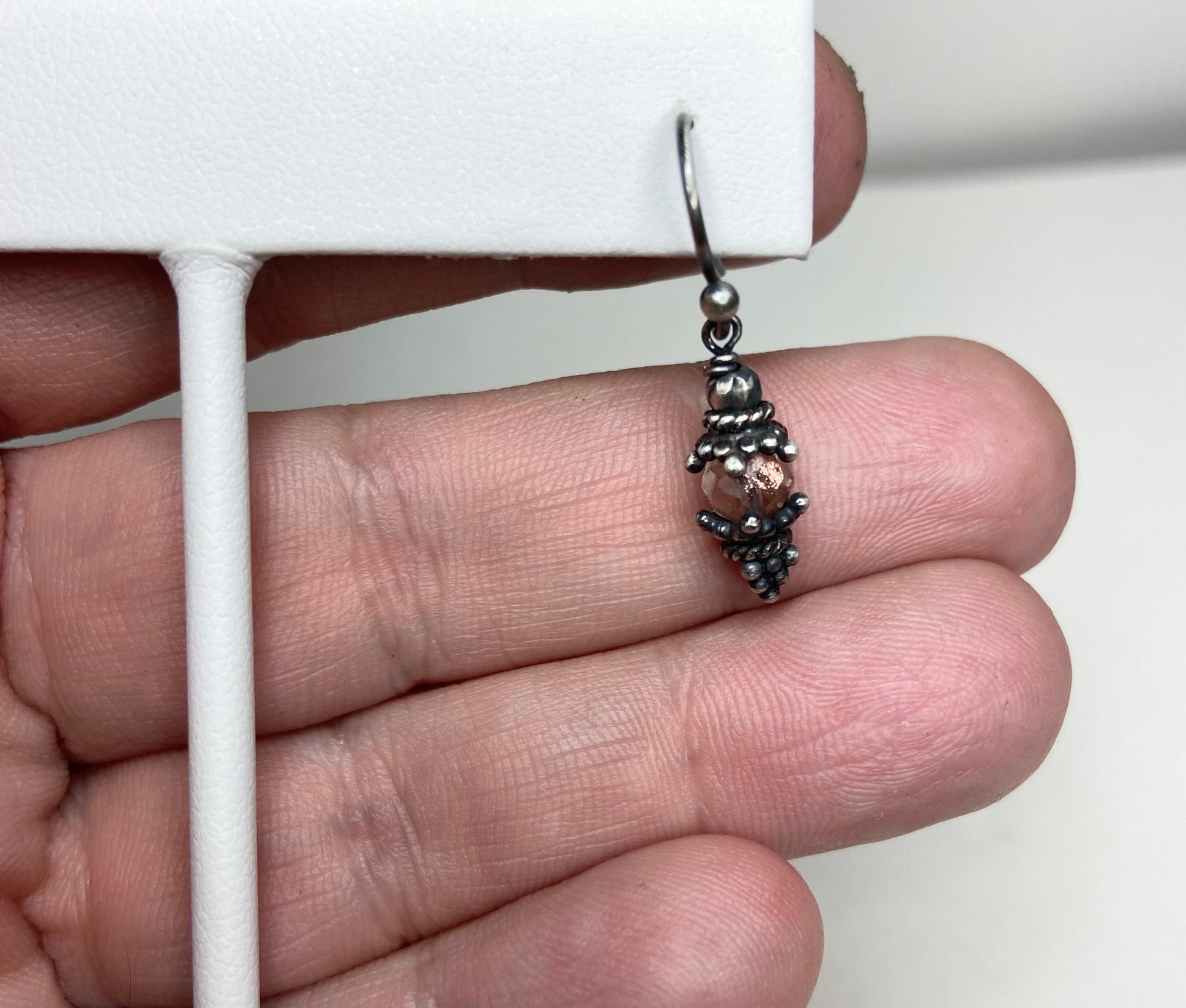 Sterling silver dangle earrings with a faceted Oregon sunstone bead.