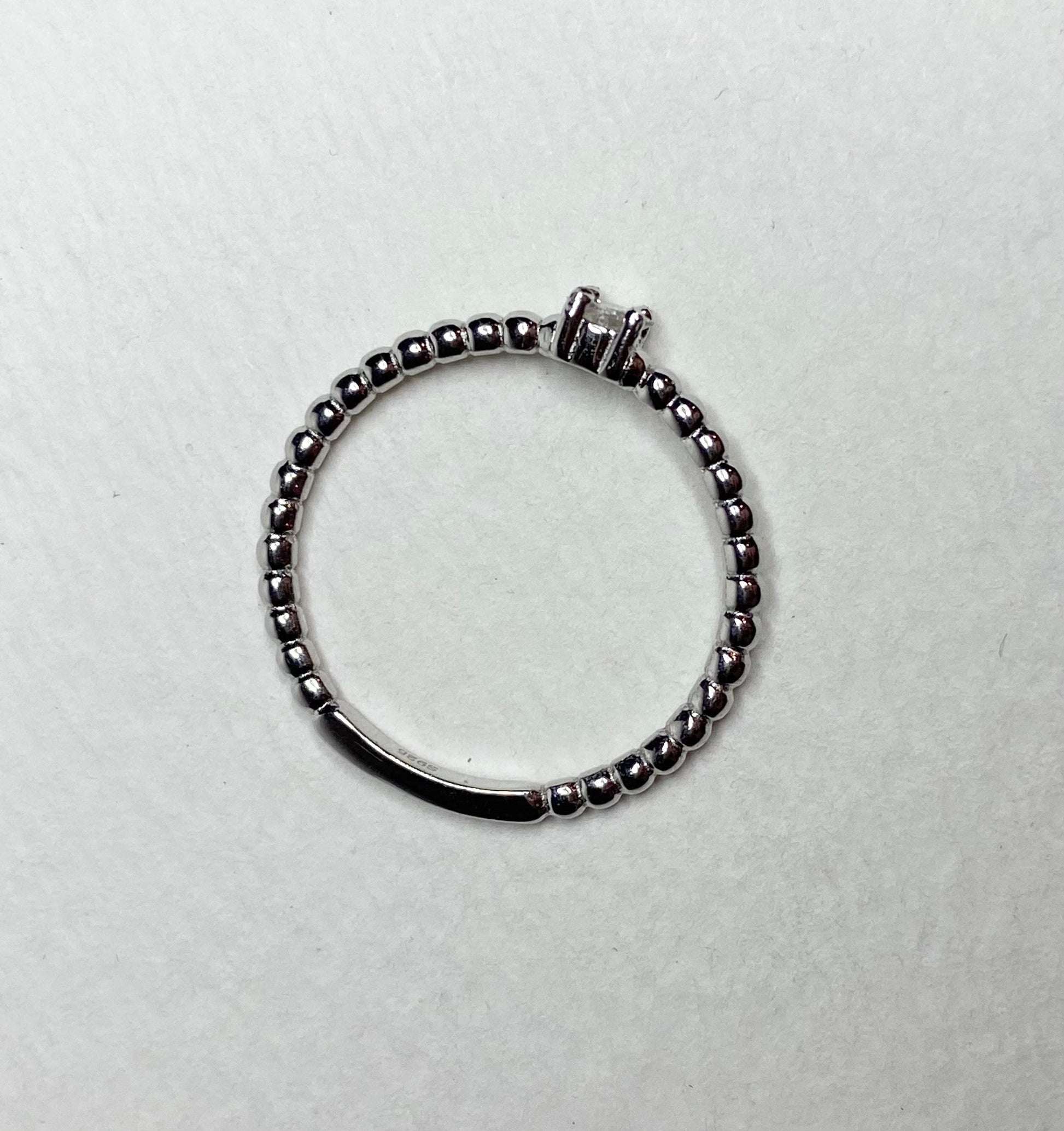 Sterling silver beaded band ring with a princess-cut diamond.