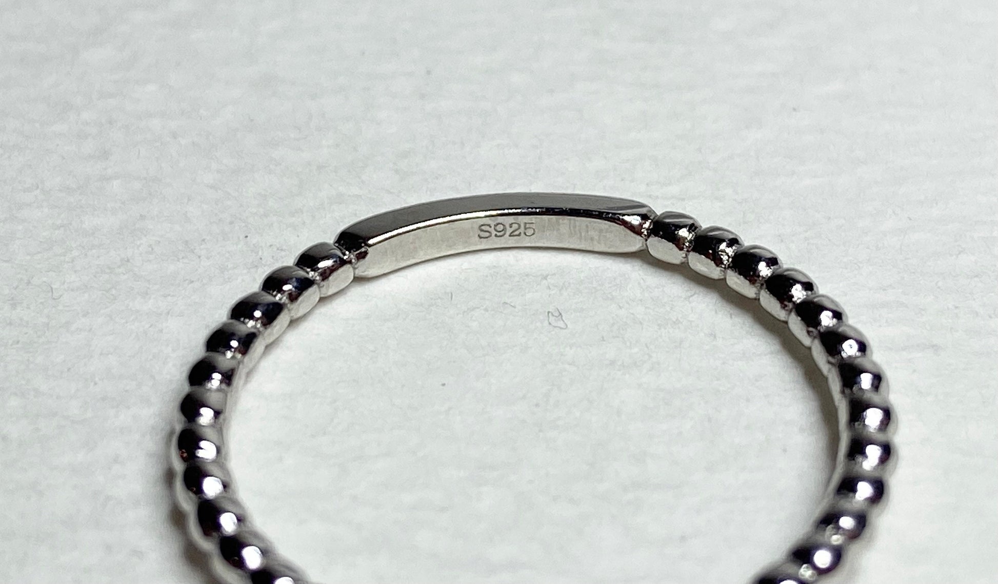 Sterling silver beaded band ring with "S925" stamp.