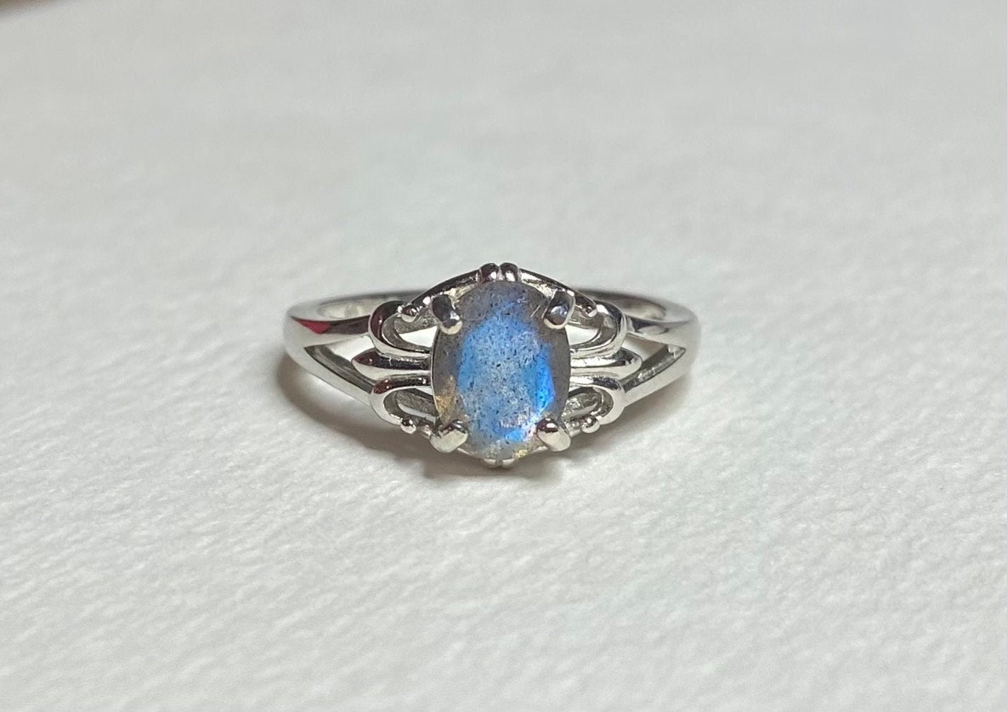 Sterling silver ring with oval blue flash labradorite in a fleur de lis setting.