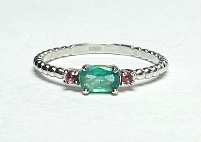 Sterling silver ring with oval emerald and two pink bixbite stones.
