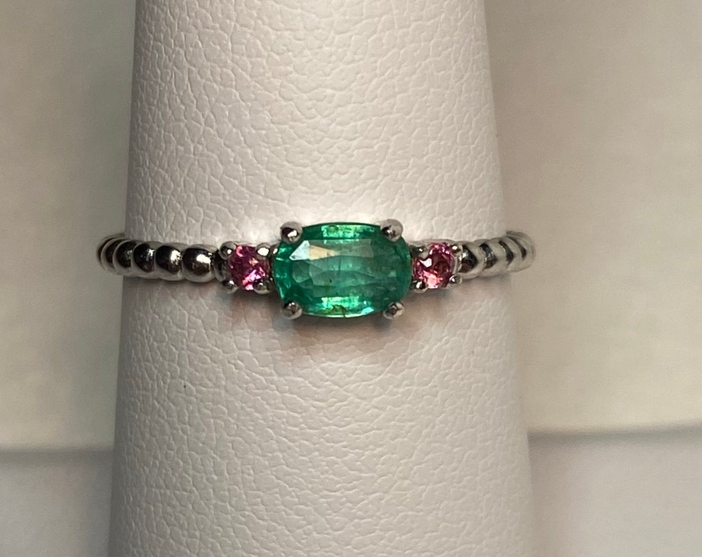 Sterling silver ring with oval emerald and two pink bixbite stones.