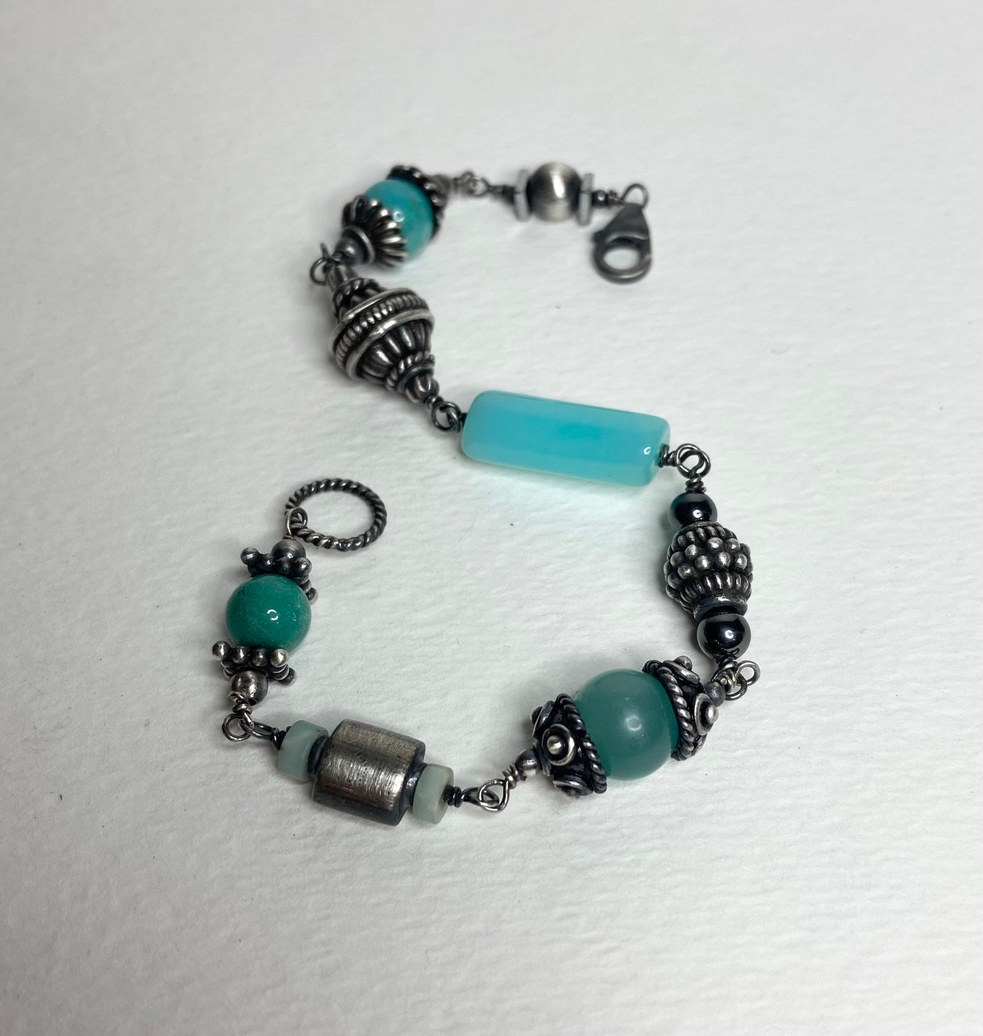 Eclectic sterling silver bracelet with blue beads and ornate silver accents.