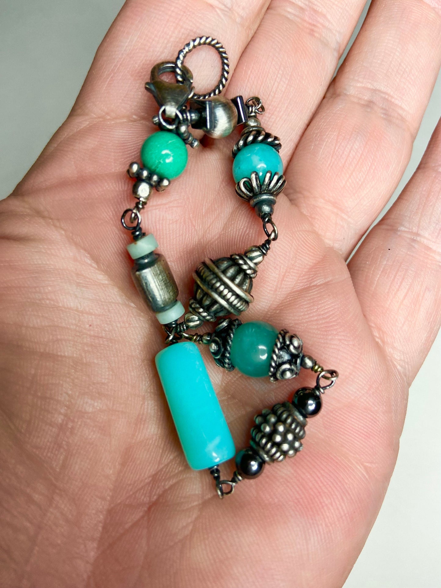 Sterling silver bracelet with blue and green beads and ornate silver accents.