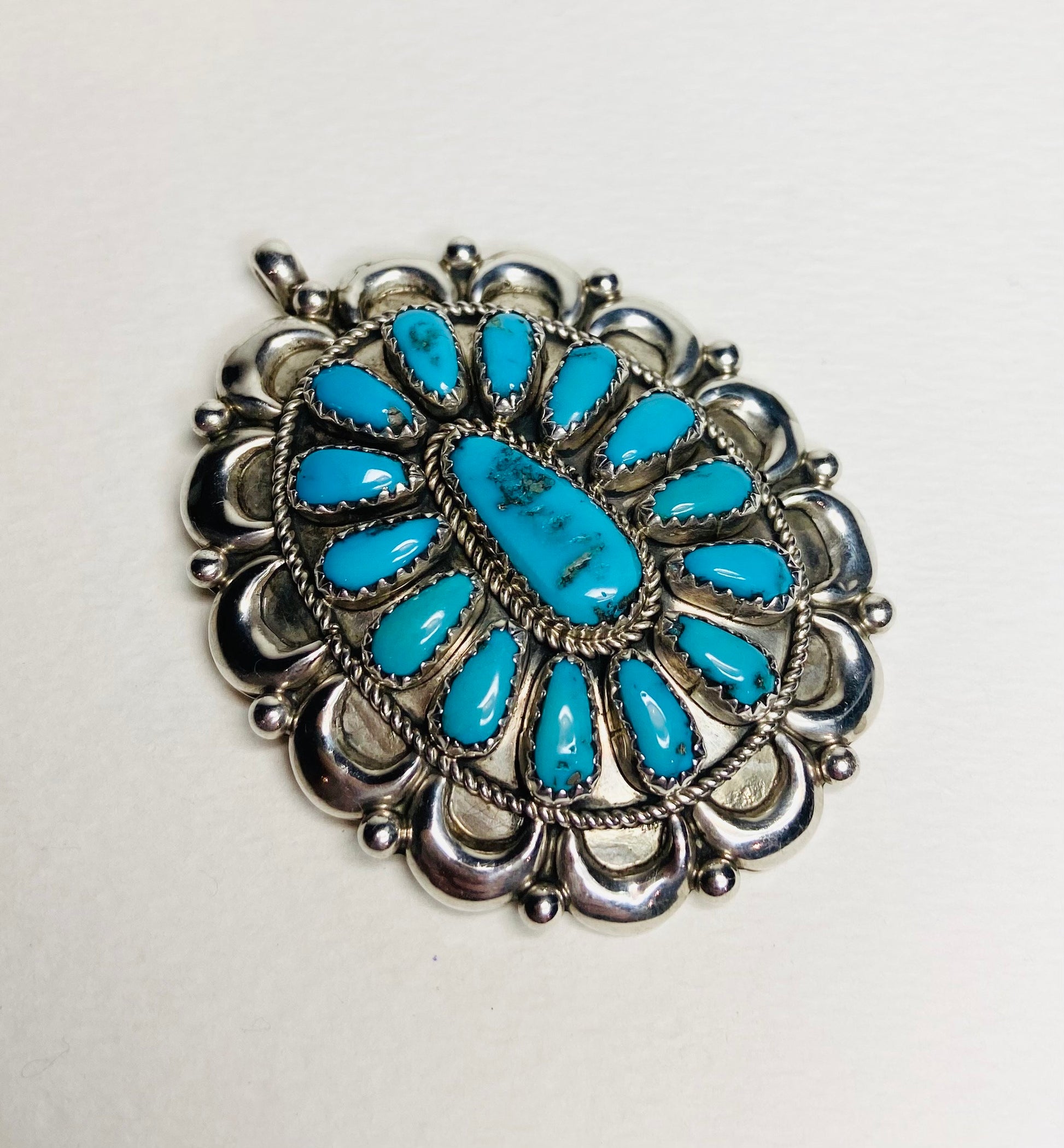 Southwest turquoise and sterling silver pendant signed by Native American artist.