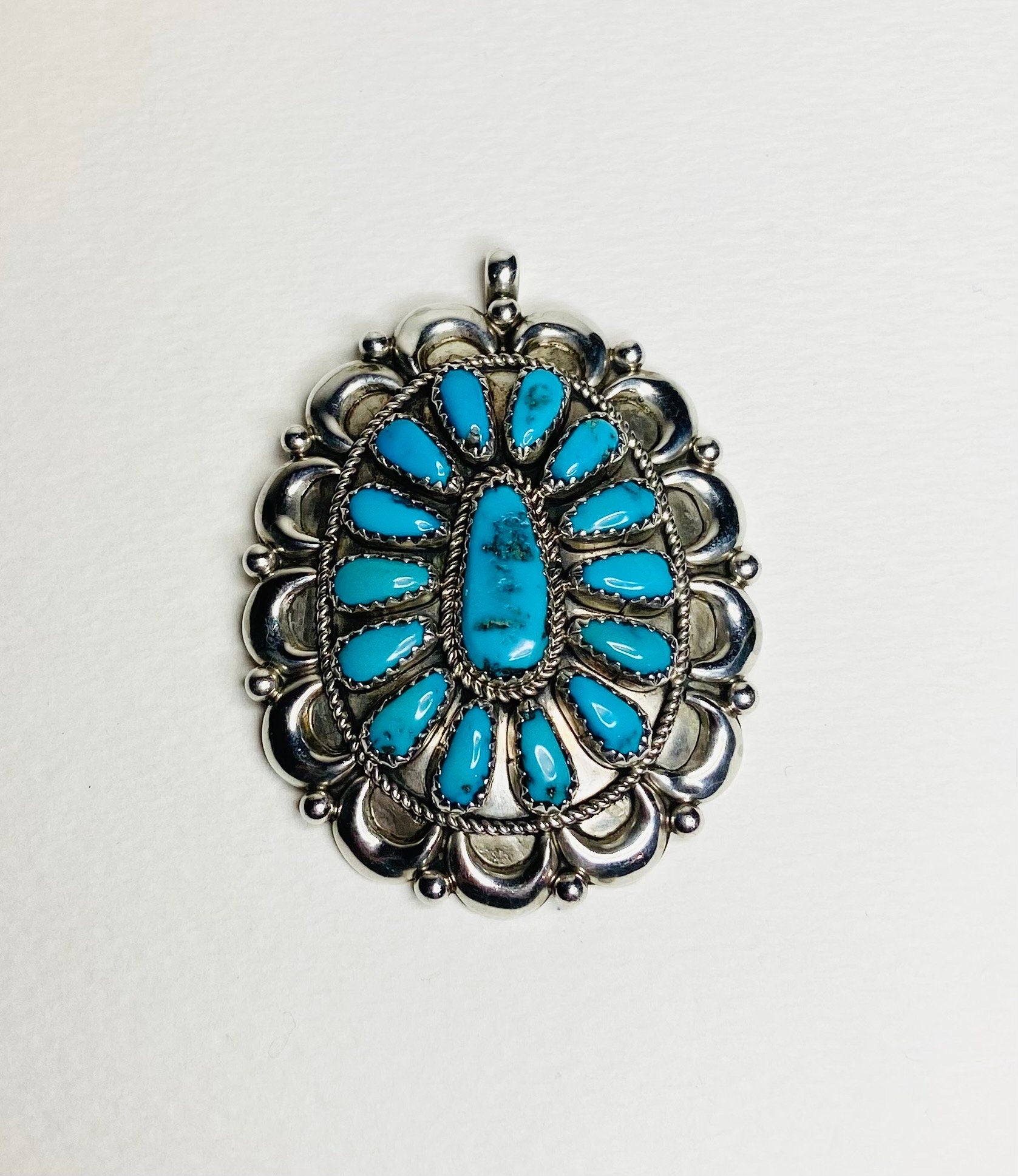Southwest turquoise and sterling silver pendant with Native American artist signature.