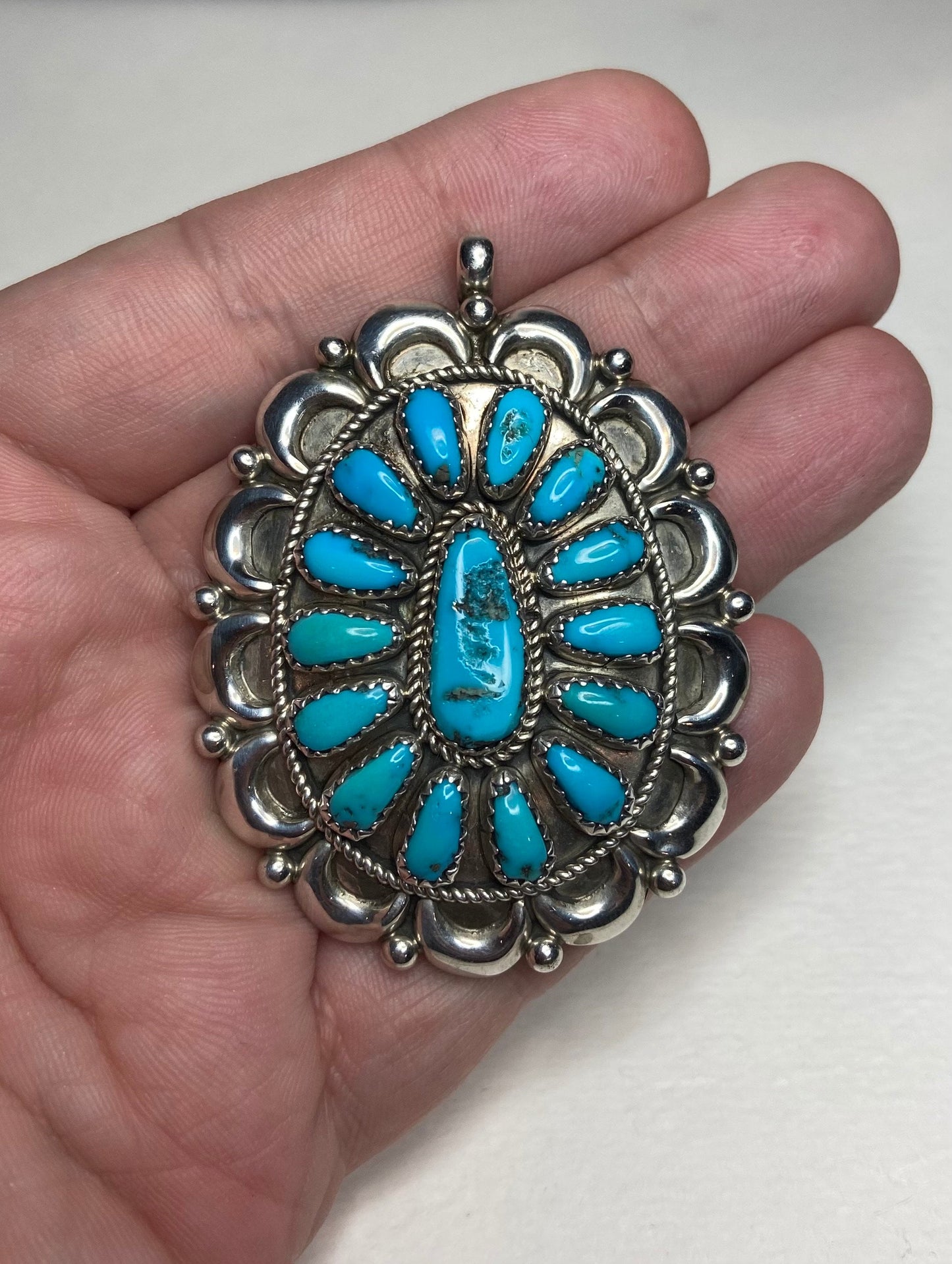 Southwest sterling silver pendant with natural turquoise stones, signed by artist.