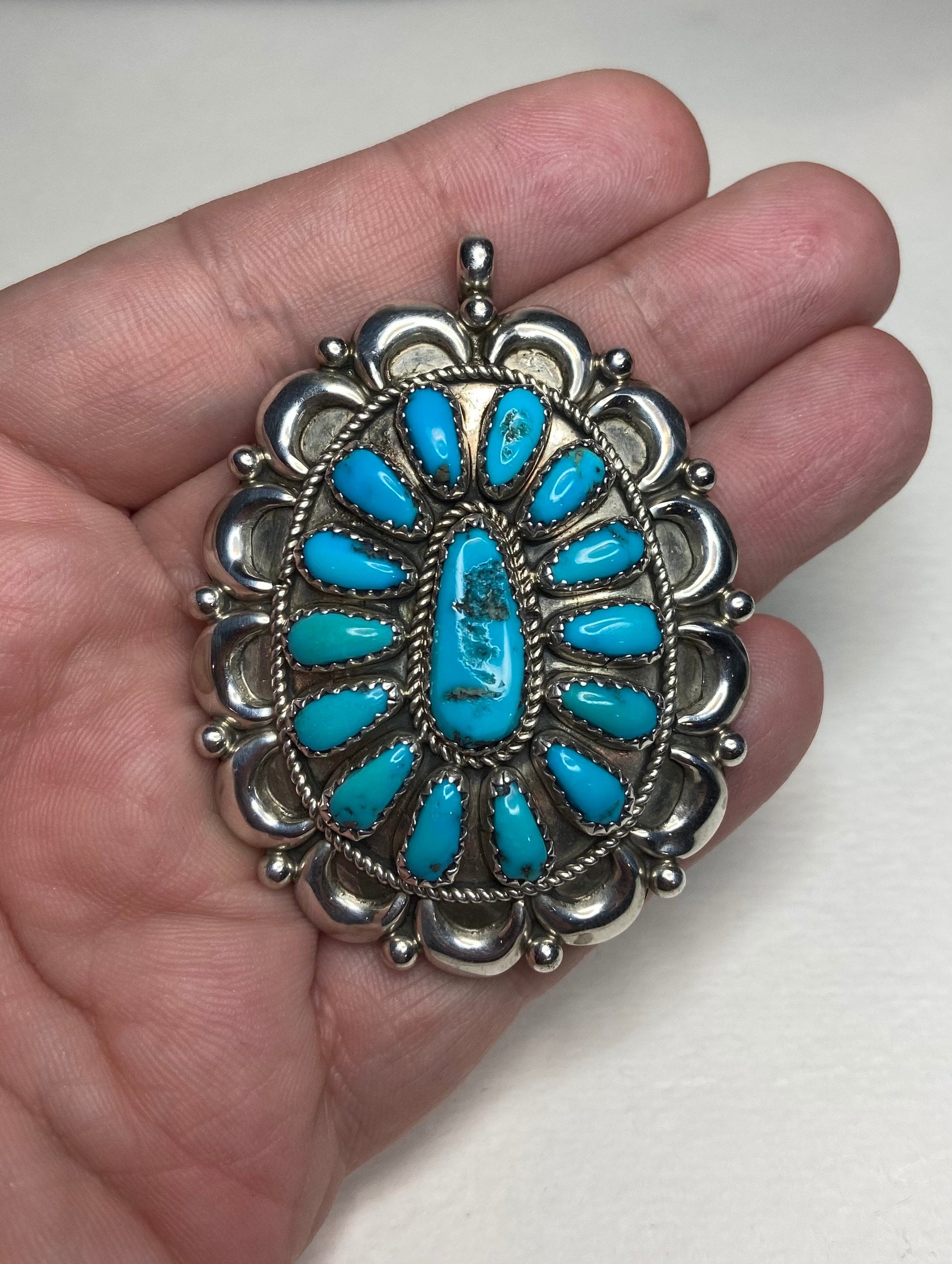 Southwest sterling silver pendant with natural turquoise stones, signed by artist.