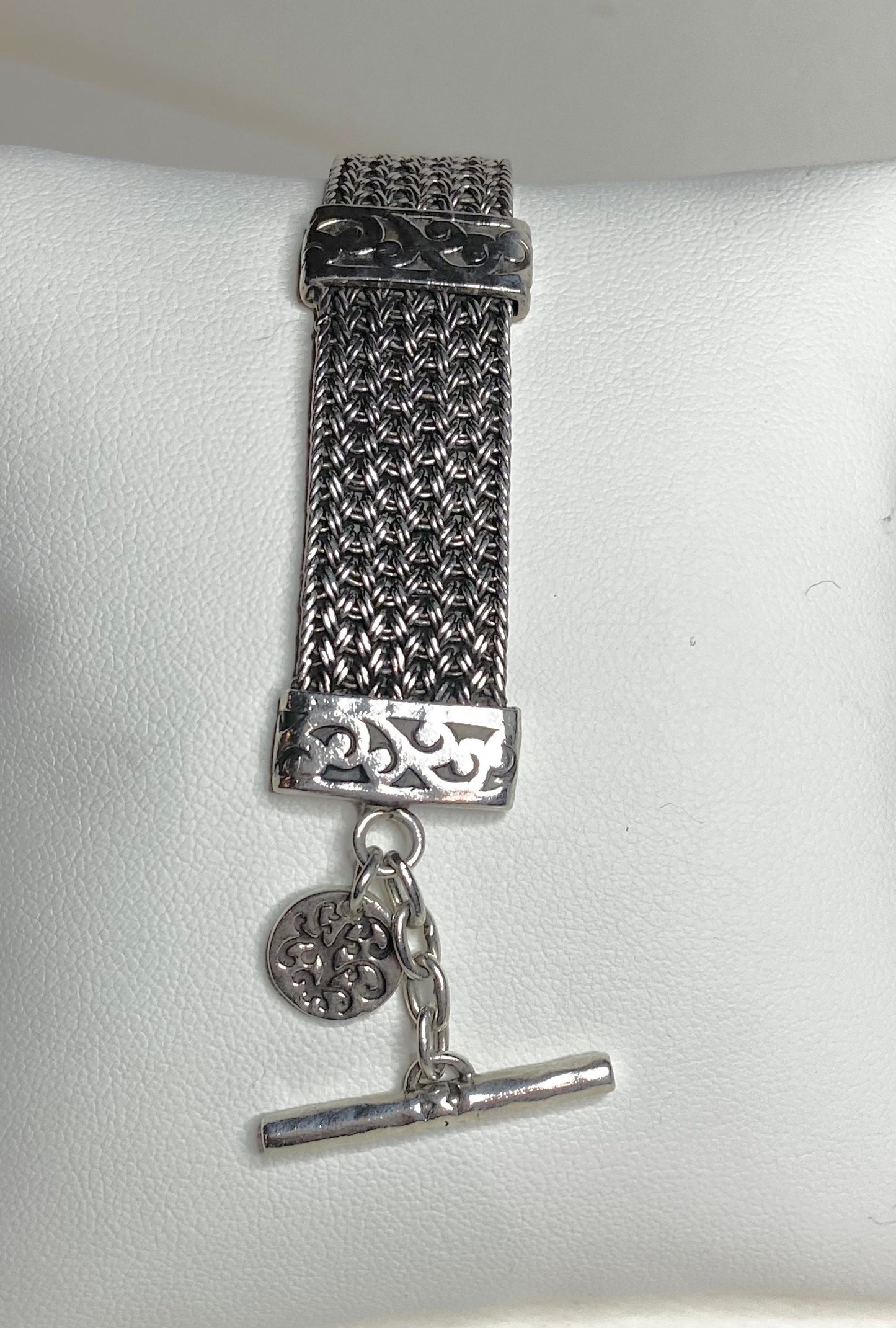 Lois Hill wide woven toggle sterling silver bracelet with a decorative charm.