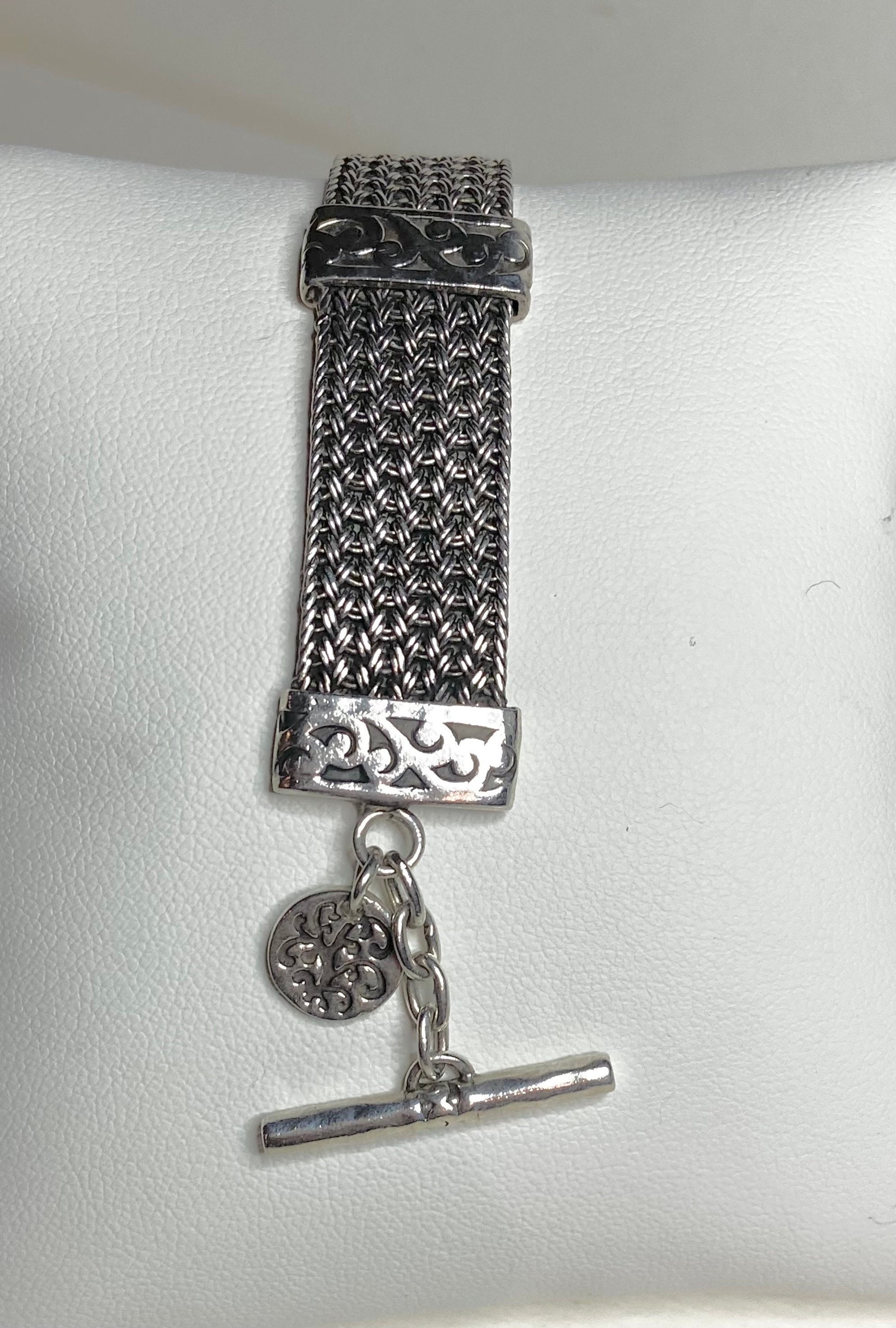 Lois Hill wide woven toggle sterling silver bracelet with a decorative charm.