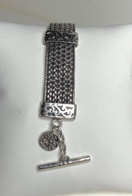 Lois Hill wide woven toggle sterling silver bracelet with a decorative charm.