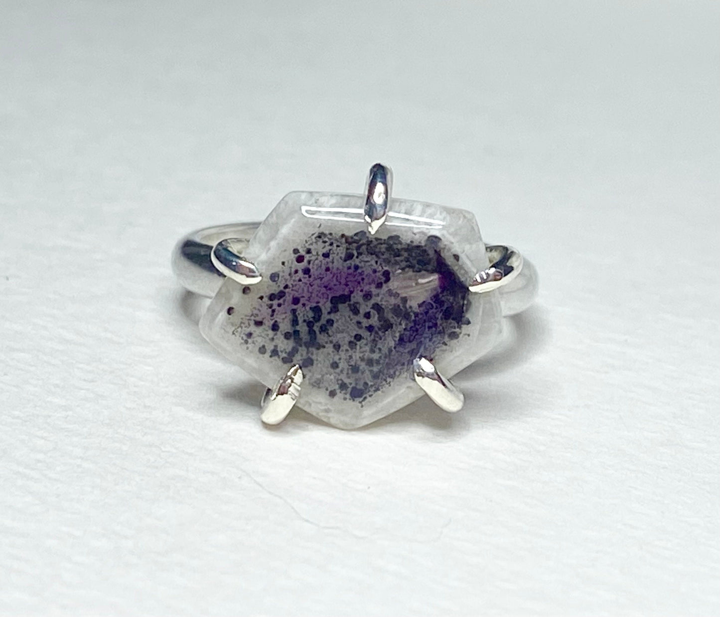 Sterling silver ring with a hexagonal quartz stone containing amethyst inclusions.