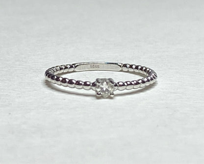 Sterling silver beaded band ring with a princess-cut diamond.