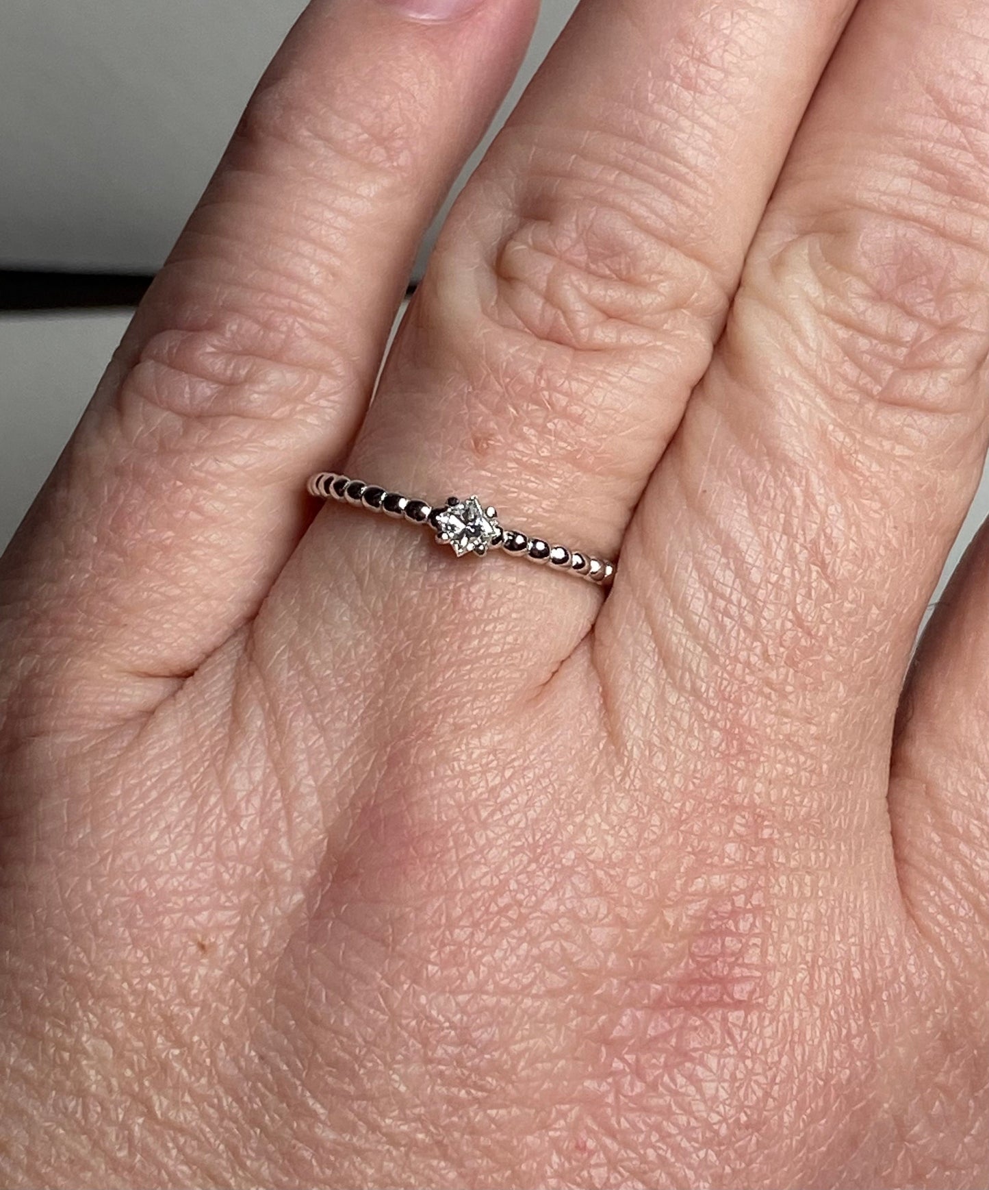 Natural diamond princess cut solitaire ring on a beaded sterling silver band.