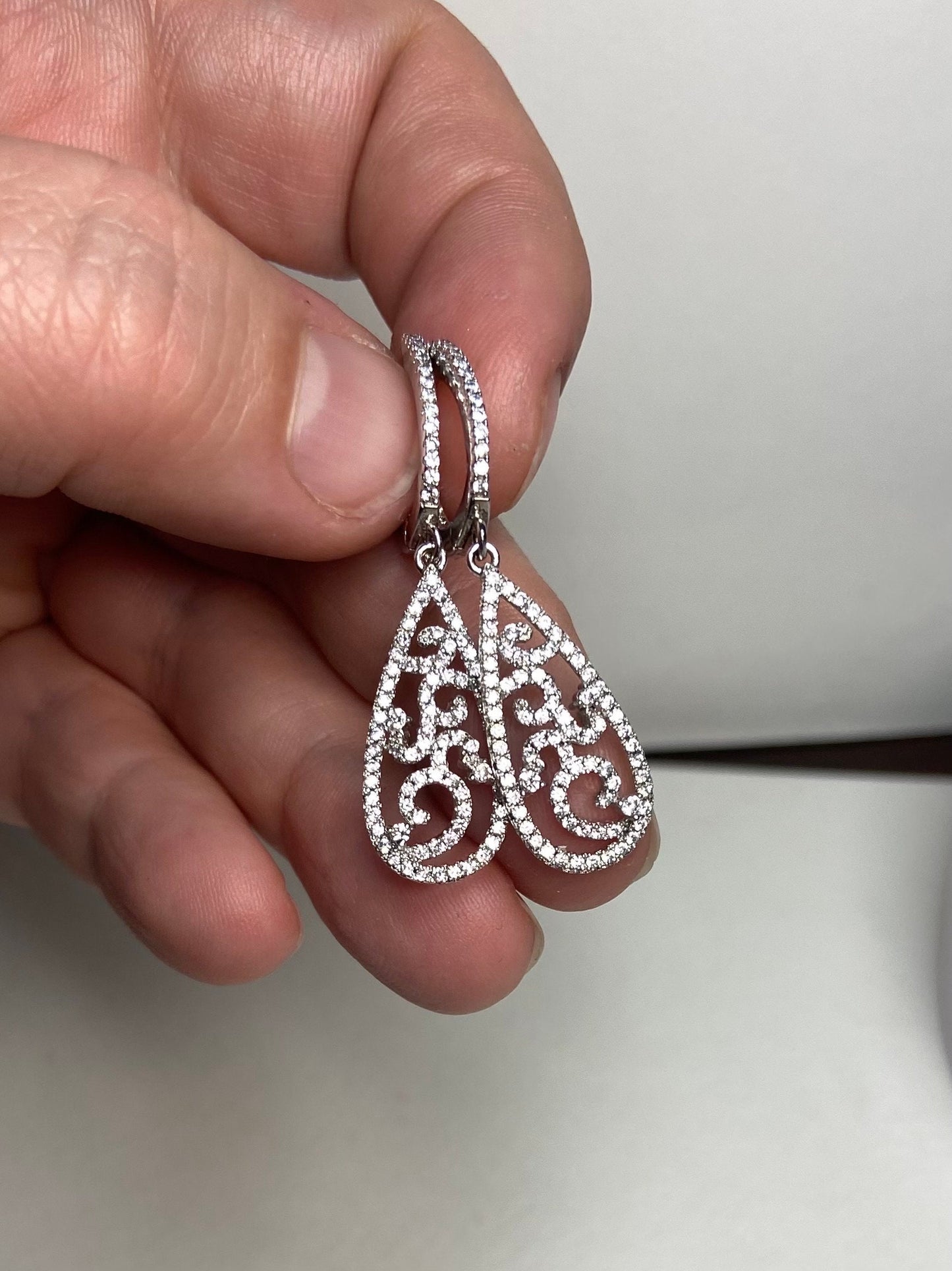 Sterling silver pave tear drop dangle earrings with lever back closure.