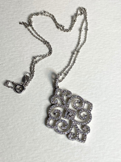 Rhodium over sterling silver pendant necklace with pave swirl design.