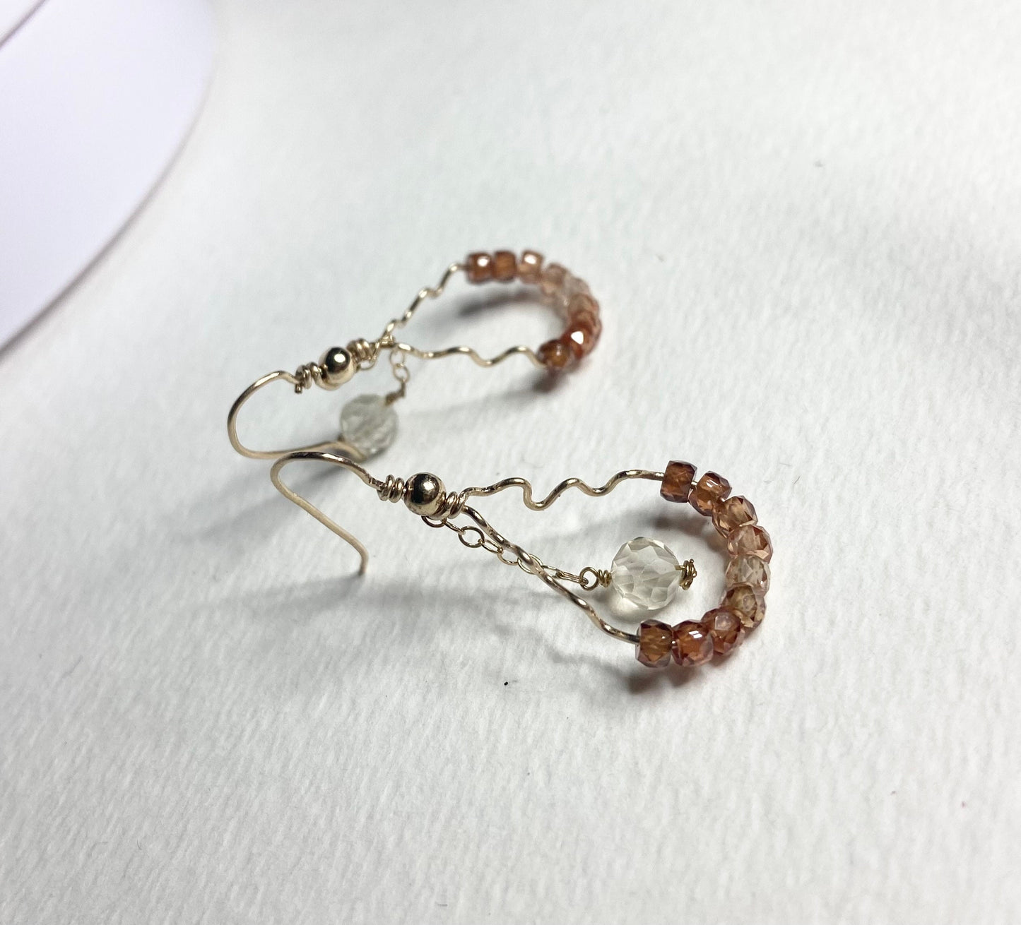 Hand-forged dangle earrings with brown zircons and a faceted Oregon sunstone.