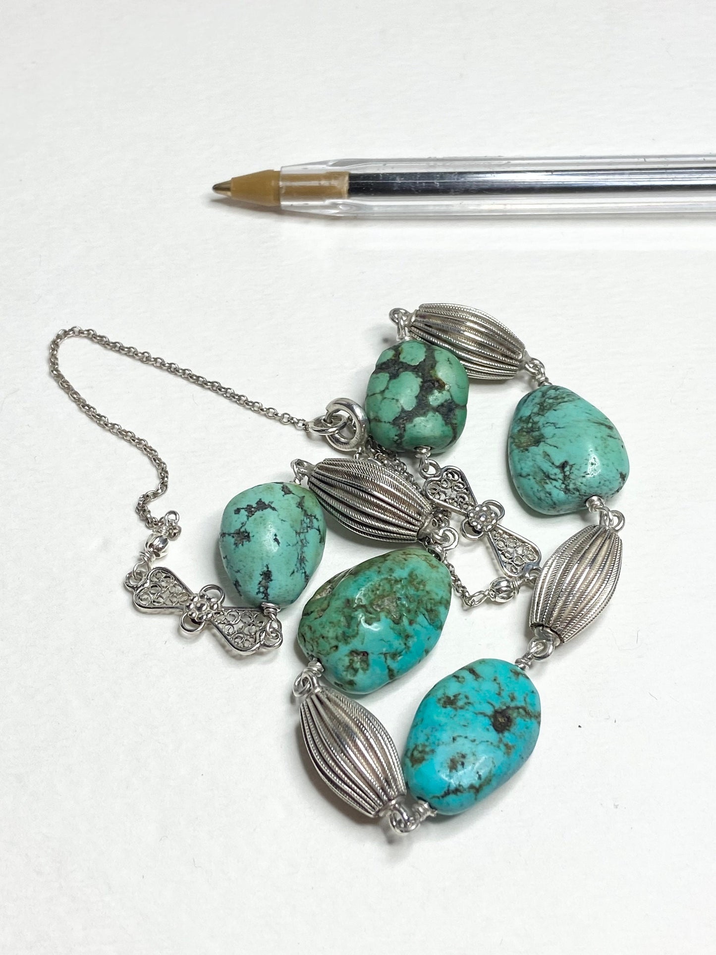 Turquoise beaded necklace with silver accents and chain.