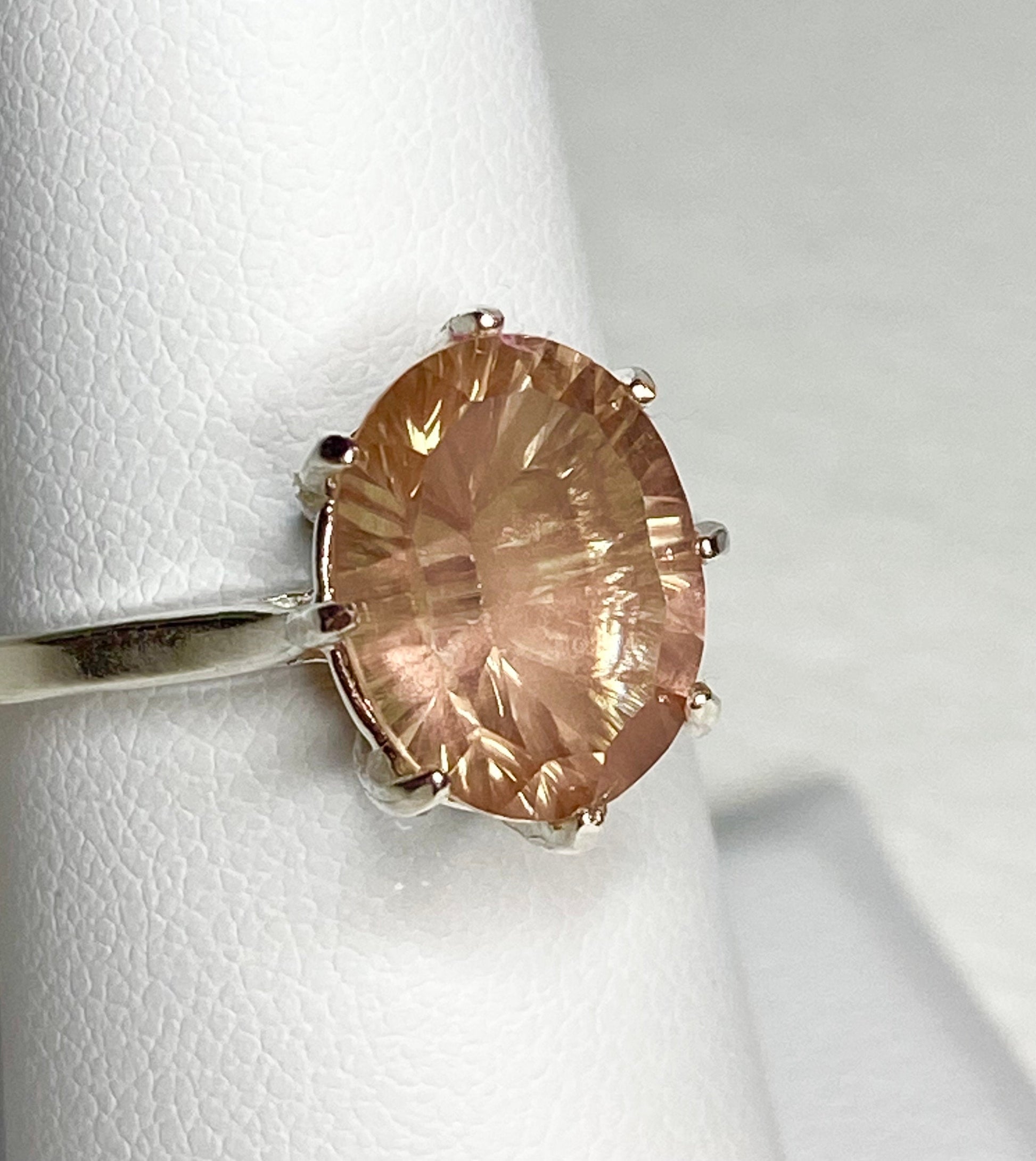 Sterling silver ring with a peach Oregon sunstone featuring a concave cut.