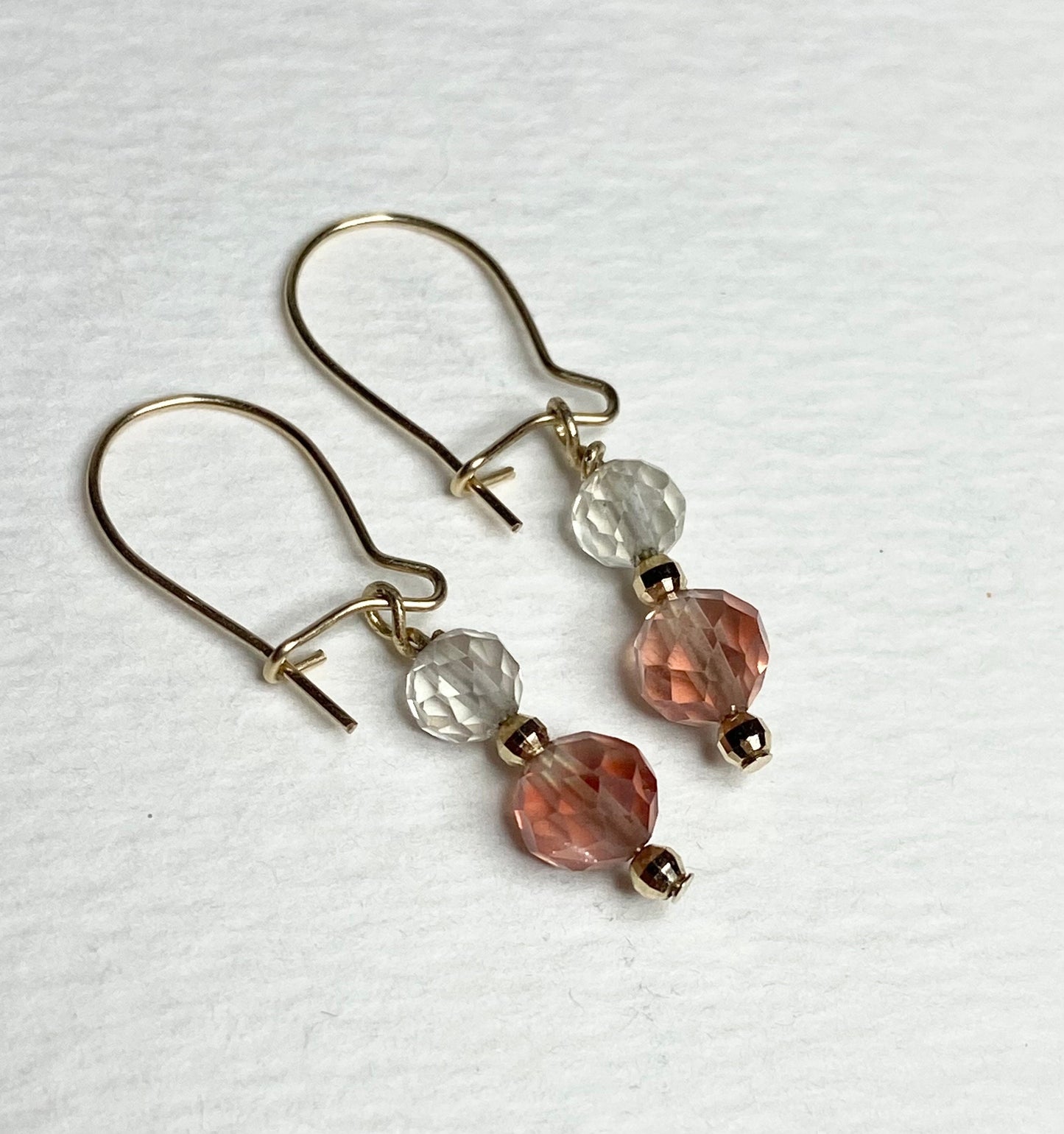 Solid 14k gold dangle earrings with faceted clear and pink Oregon Sunstone beads.