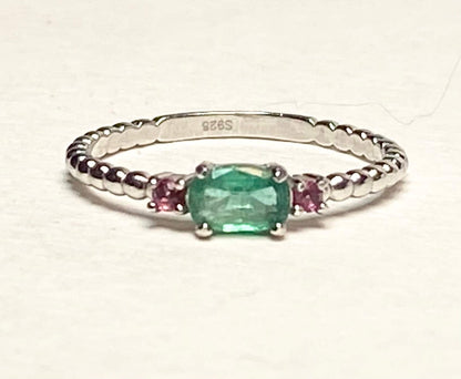 Sterling silver ring with oval emerald and two bixbite stones.