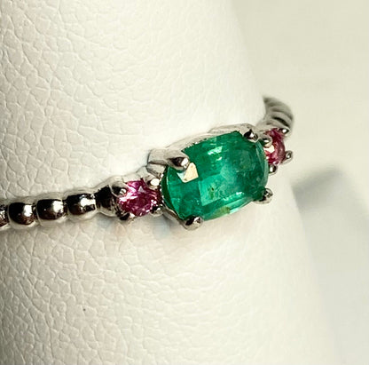 Sterling silver ring with an oval emerald and two pink bixbite stones.