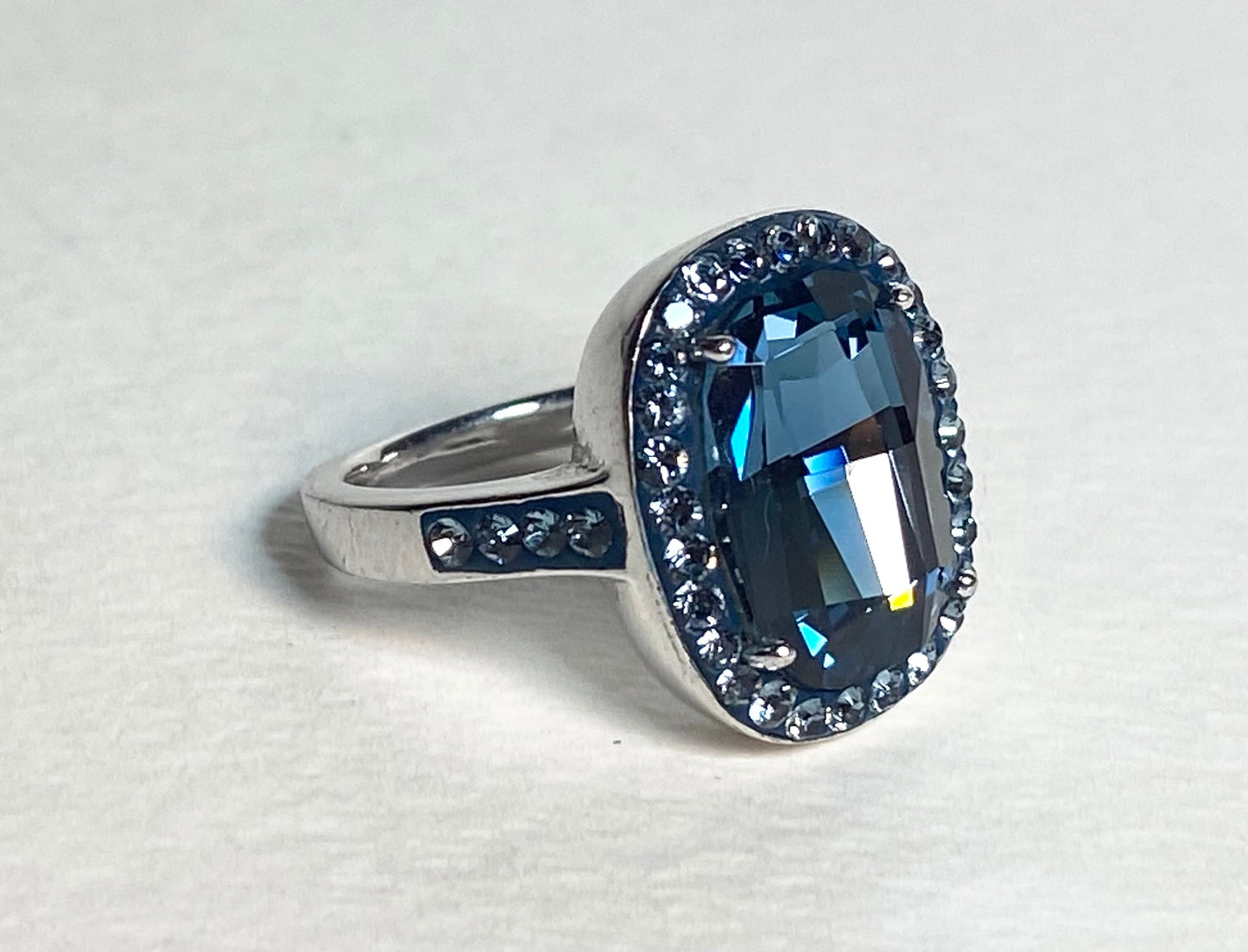 Sterling silver ring with a large oval Montana blue Swarovski crystal surrounded by smaller crystals.