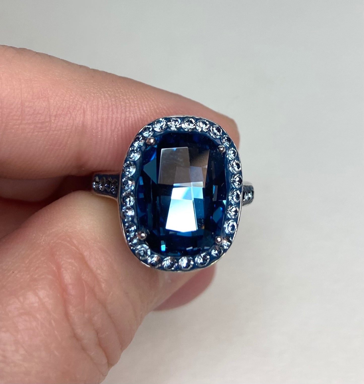 Sterling silver ring with a large oval Montana blue Swarovski crystal surrounded by smaller crystals.